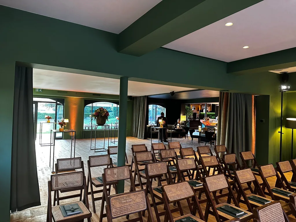 Rows of chairs set for a ceremony in Le Barbizon, with a view towards the garden