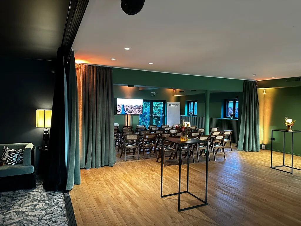Salle du Barbizon aménagée en conférence, avec des chaises en rangées et un écran