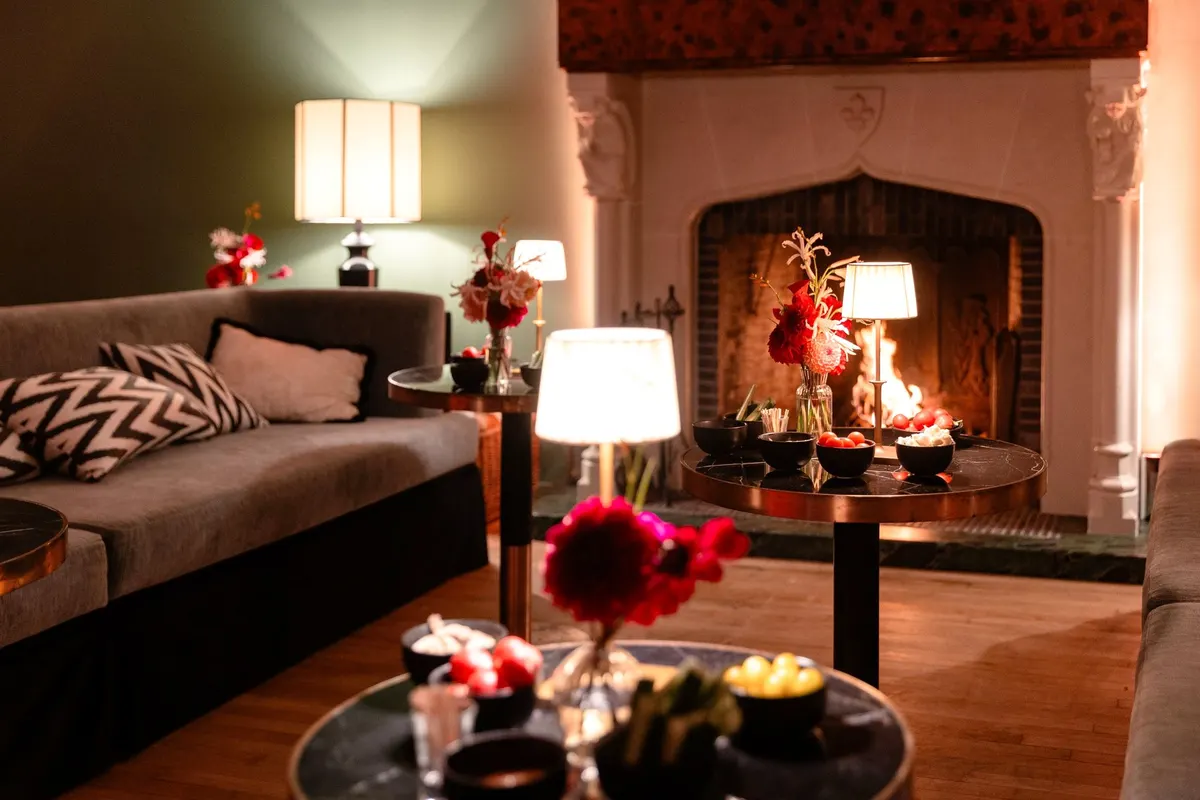 Canapés, lampes et bouquets dans le coin cheminée du Barbizon