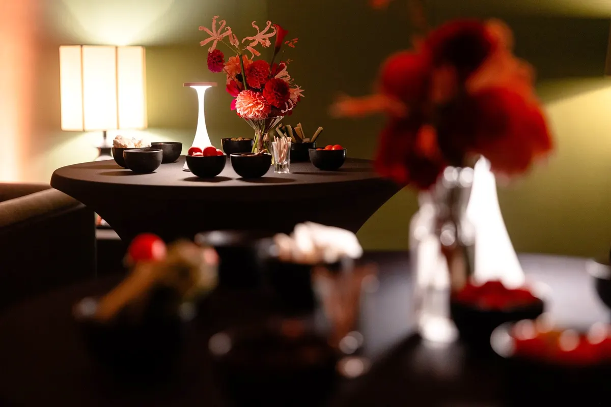Mange-debout, bouquets et lampe dans le salon du Barbizon en soirée